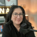 Angela Briones sits behind a microphone