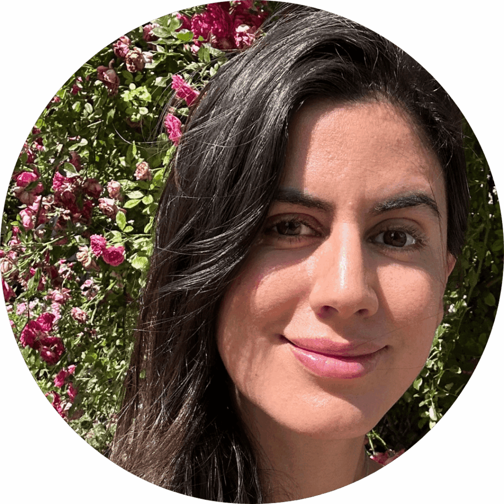 Alitzel Guerrero Santibañez stands in front of a flowering outdoor wall, smiling at the camera