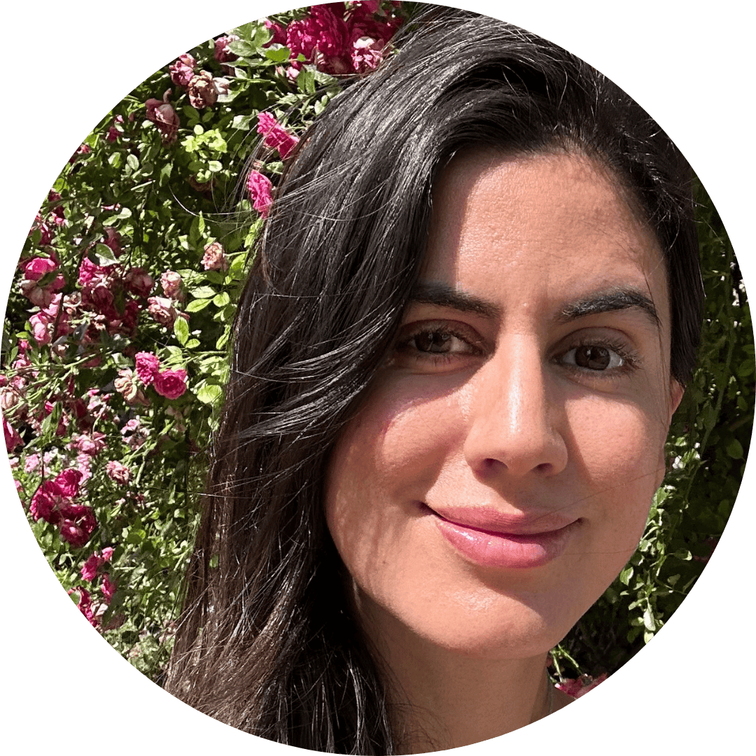 Alitzel Guerrero Santibañez stands in front of a flowering outdoor wall, smiling at the camera