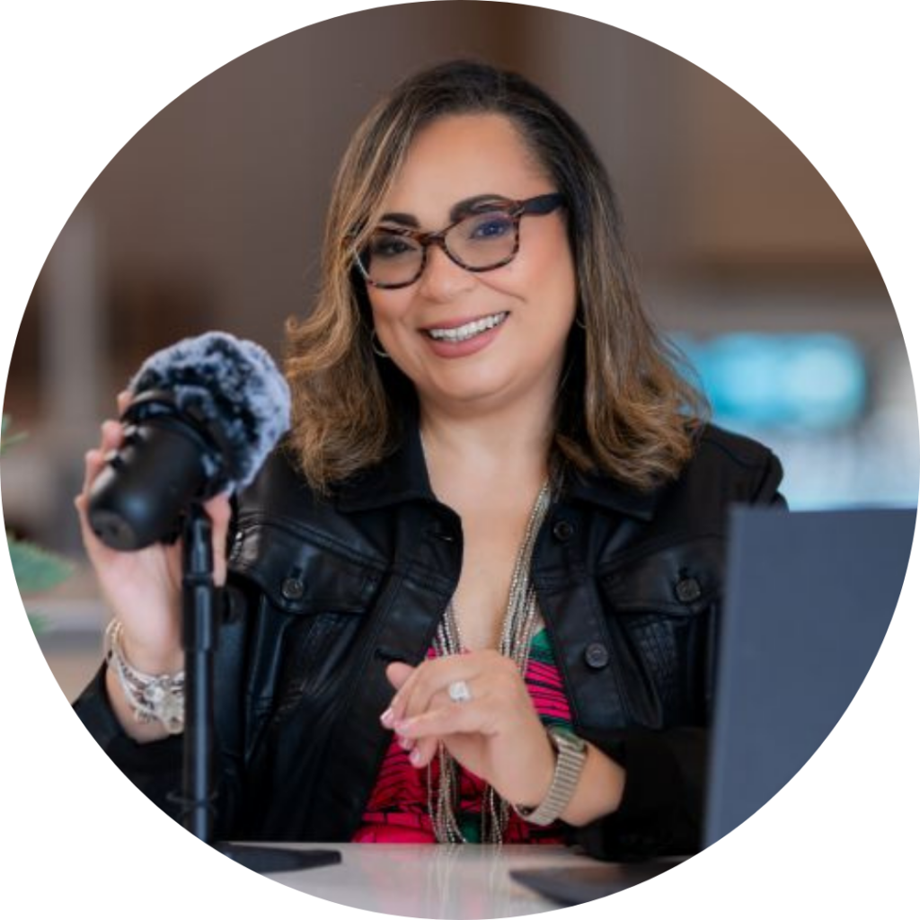 Jacqueline Vazquez sits at a desk with a microphone and computer screen in front of her