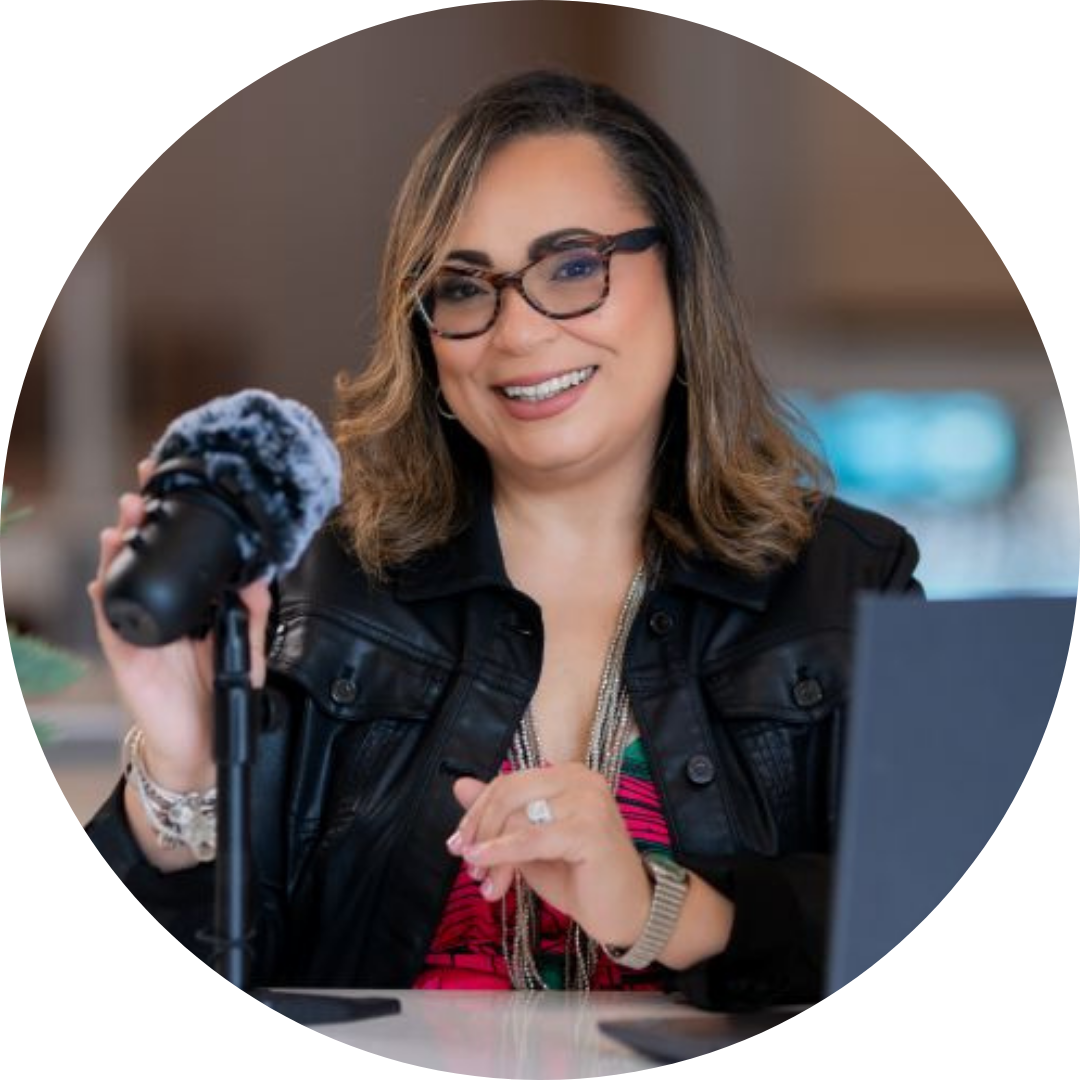 Jacqueline Vazquez sits at a desk with a microphone and computer screen in front of her