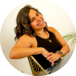 Mafe Salazar leans with one arm on the back of the chair, smiling