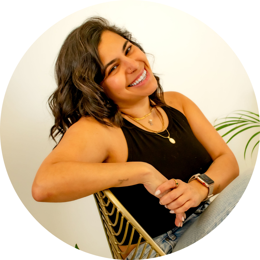 Mafe Salazar leans with one arm on the back of the chair, smiling