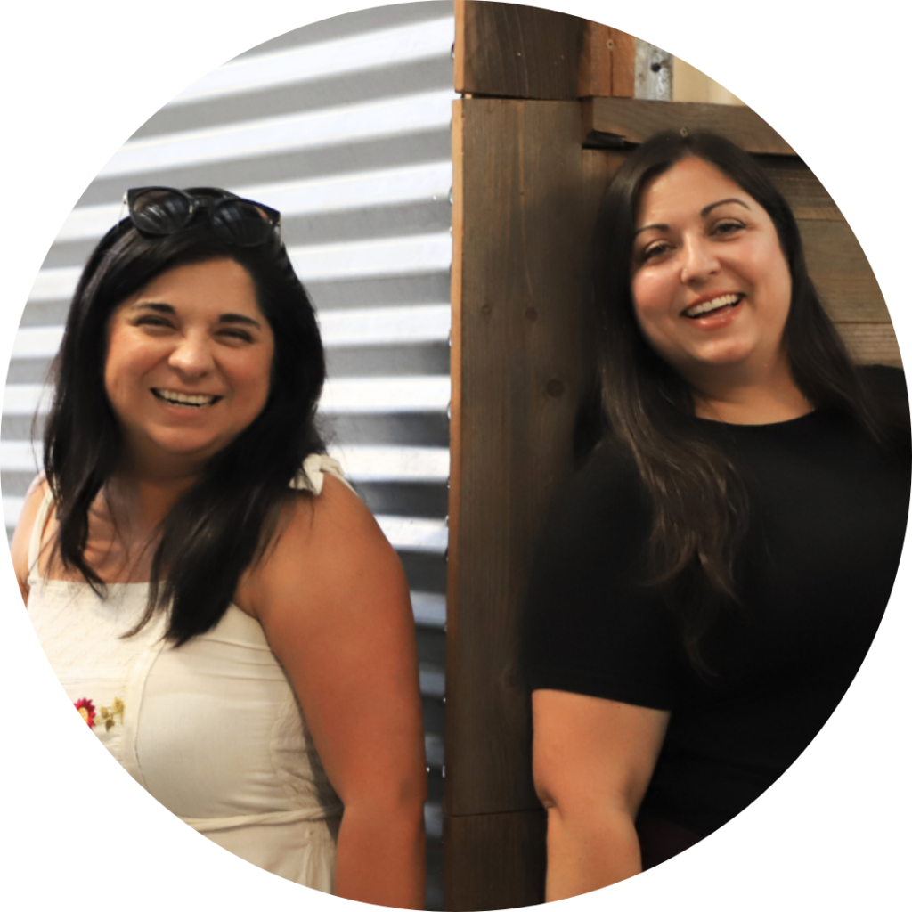Nicole Moreno-Deinzer and Gisel Martín stand back to back smiling at the camera