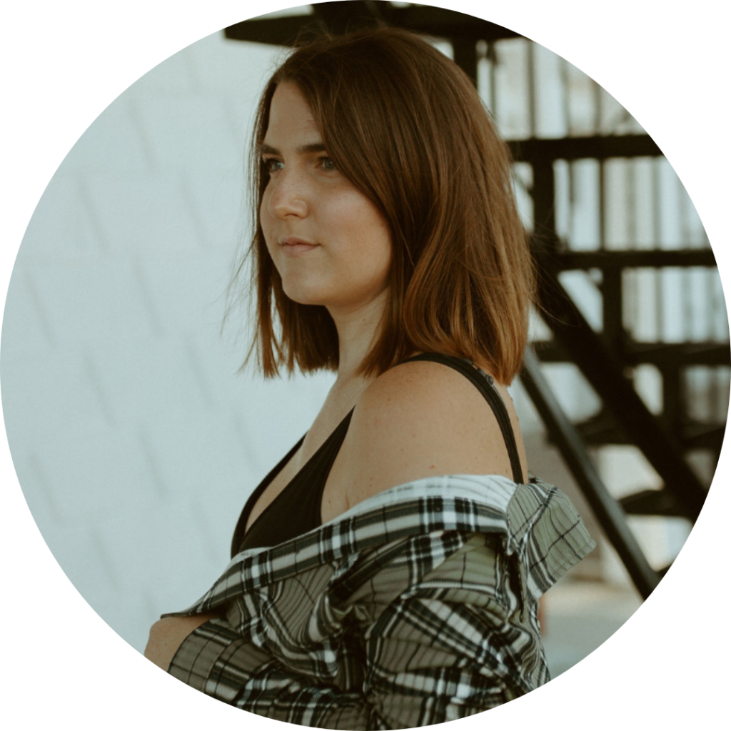 Steph Wharton stands looking to the left with a flannel hanging off her shoulder