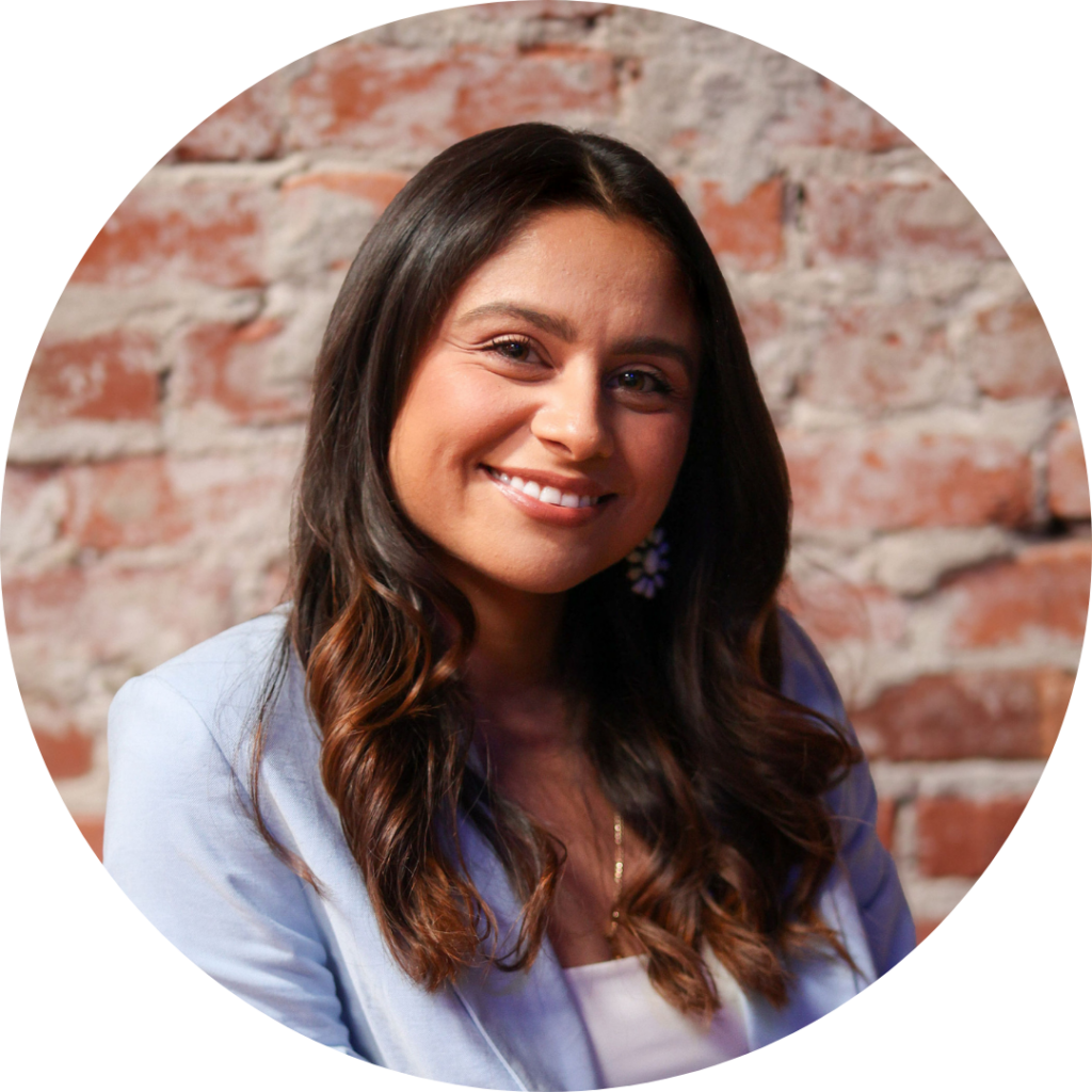 Yvonne Armenta against a brick wall smiles at the camera