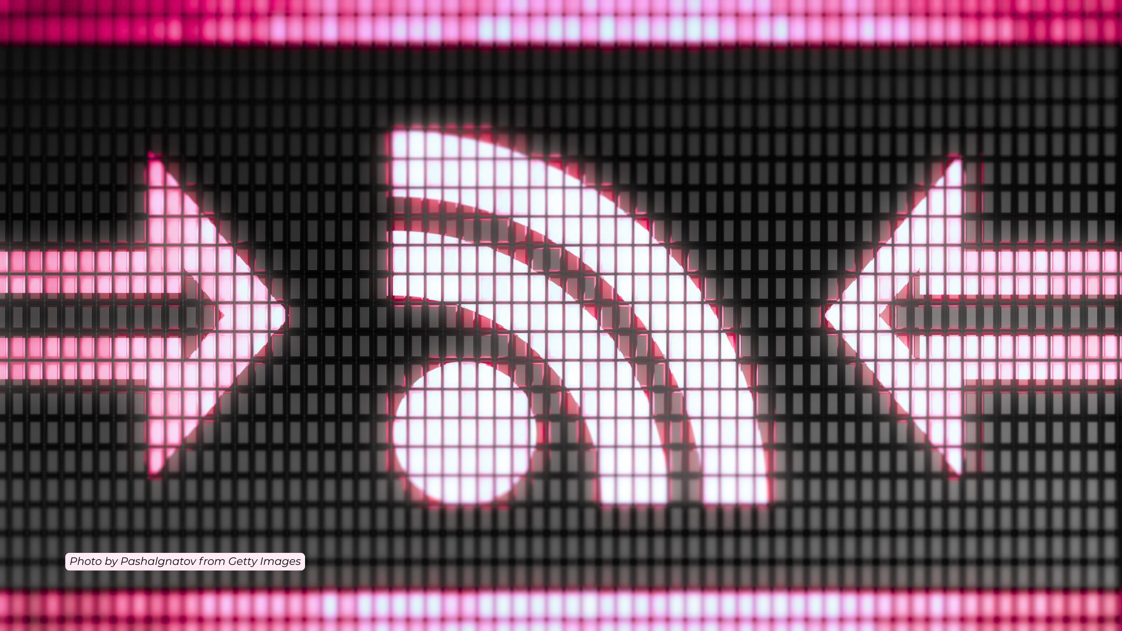 Black screen with pink lights that form two arrows pointing to a lit up RSS feed figure in the middle. The text on the photo reads Photo by Pashalgnatov from Getty Images in black text against a light pink background.