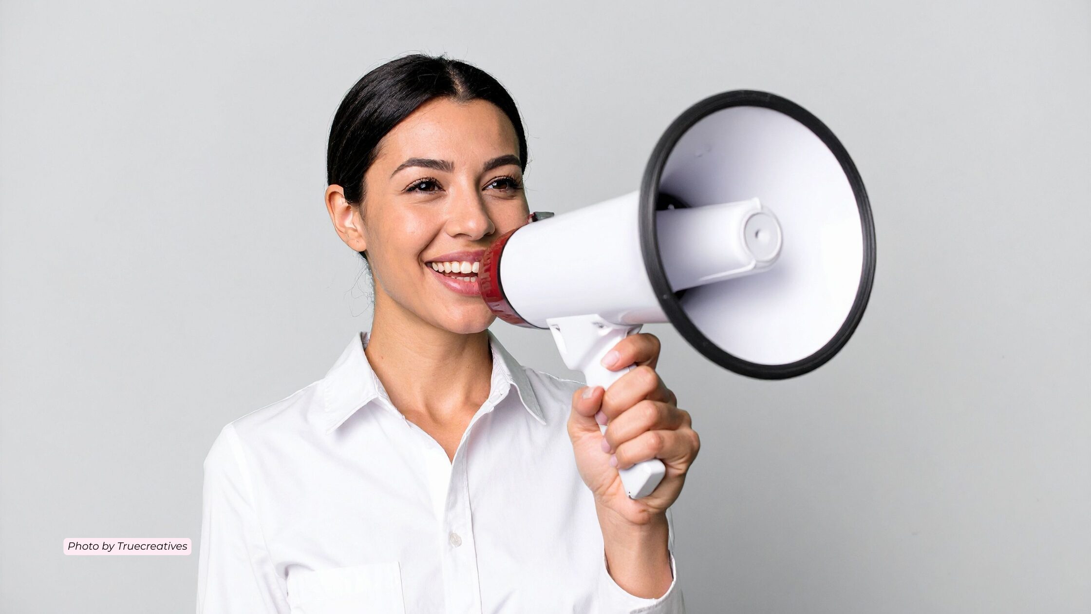Woman in a white shirt holding a white megaphone