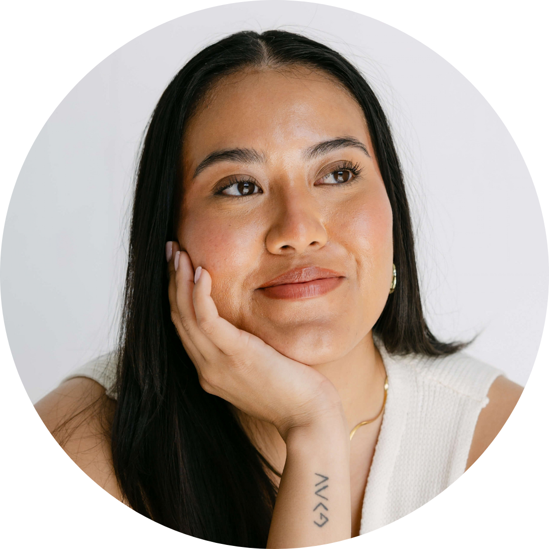 Guadalupe Calderon hold her right hand to her face as she smiles to something off to the side. A small tattoo is visible on her wrist.
